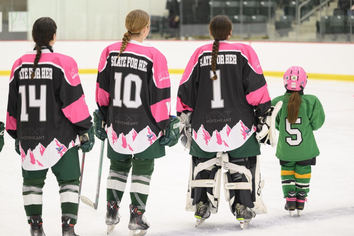 From left to right: Aliza Torop ’28, Anna Mathias ’27, and Julia Echavarria ’25. Echavarria is standing with a young skater during the United States national anthem
